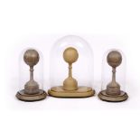 A PAIR OF PAINTED TURNED WOODEN BALL FINIALS each with a glass dome on turned wooden base, the domes