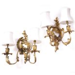 A PAIR OF GILT METAL TWO BRANCH WALL LIGHTS with acanthus leaf scrolling decoration, each