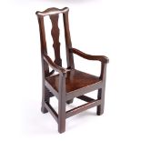 AN ANTIQUE ELM CHILD'S OPEN ARMCHAIR with shaped splat back, solid seat and legs united by