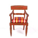 A RED PAINTED INDO-COLONIAL OPEN ARMCHAIR with flower decoration and overstuffed upholstered seat,