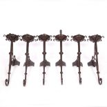 A GROUP OF SIX BURGUNDY PAINTED WROUGHT IRON WALL LIGHTS with shaped mounts, with scrolling