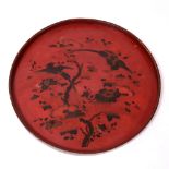 AN ANTIQUE JAPANESE CIRCULAR RED LACQUERED TRAY decorated with chamilia flowers and exotic birds,