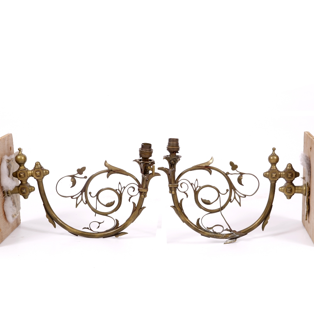A PAIR OF VICTORIAN BRASS HINGED WALL LIGHTS with scrolling Gothic revival foliate decoration,