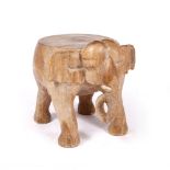 A HARDWOOD LOW OCCASIONAL TABLE carved in the form of an elephant, 47cm wide x 51cm high