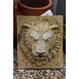 A RECONSTITUTED STONE FOUNTAIN MASK OF A LION'S FACE on square backing, 29.5cm wide