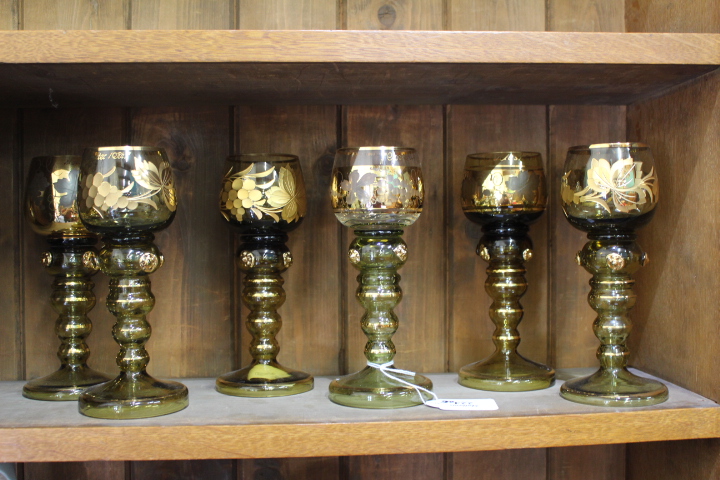 SIX GILT PAINTED GLASS GOBLETS with gilt painted decoration and shaped prunts on knopped stem,