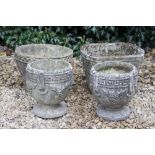 A PAIR OF COMPOSITE STONE GARDEN URNS of Gothic design, each 26cm in height together with two