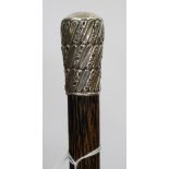 A VICTORIAN WALKING CANE with unmarked white metal embossed decorated cap with monogram, dated 1890,