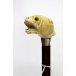 A MID 19TH CENTURY WALKING CANE with an ivory handle carved into the form of a dog bearing its teeth