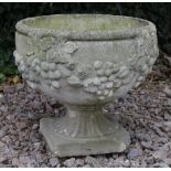 A CAST RECONSTITUTED STONE PLANTER decorated with vines and bunches of grapes, 39cm high