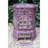 A FRENCH PURPLE ENAMEL HEXAGONAL WOOD BURNING STOVE with pierced decoration and applied flower