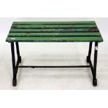 AN OLD WROUGHT IRON GARDEN BENCH OR TABLE with green painted wooden slats to the top, 91cm wide x