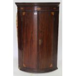 A 19TH CENTURY MAHOGANY BOW FRONTED CORNER CABINET with box line inlay, 114cm x 71cm