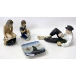 FOUR PIECES OF ROYAL COPENHAGEN PORCELAIN consisting of a nude girl on a rock, a young man eating, a