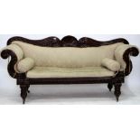 A 19TH CENTURY MAHOGANY CARVED FRAME SCROLLING ARM SOFA standing on fluted legs terminating in brass