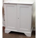 AN ANTIQUE WHITE PAINTED PINE FLOOR STANDING CUPBOARD with panel doors and bracket feet, 89cm wide x
