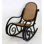 A 20TH CENTURY BLACK PAINTED THONET BERGERE CANED ROCKING CHAIR