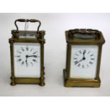 TWO LATE 19TH / EARLY 20TH CENTURY BRASS CARRIAGE CLOCKS with white enamel fronts and a Roman