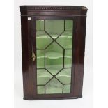 A GEORGE III MAHOGANY CORNER CABINET with astragal glazed door and shaped cornice, 74cm x 112cm