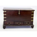A MAHOGANY COLONIAL STYLE AND BRASS BOUND COFFER OR MULE CHEST fitted with three frieze drawers