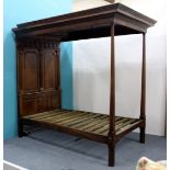 AN OAK FRAMED CANOPY BED with panel decoration and fluted pilaster columns to the head and turned