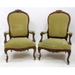 A PAIR OF LATE 19TH / EARLY 20TH CENTURY FRENCH CARVED OPEN ARMCHAIRS on scrolling cabriole legs,
