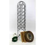 A WROUGHT IRON WINE BOTTLE RACK 127cm in height, a gilded gesso oval wall mirror, a mirrored wall
