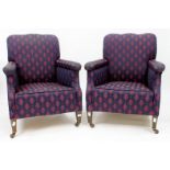 A PAIR OF ARMCHAIRS upholstered in a purple and pink leaf design, standing on square tapering