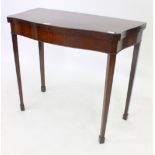 A 19TH CENTURY MAHOGANY SERPENTINE FRONTED CARD TABLE standing on square tapering legs terminating