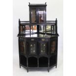 A LATE 19TH CENTURY AESTHETIC MOVEMENT EBONISED CORNER CABINET with glazed doors and turned