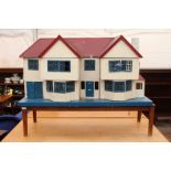 A VINTAGE 20TH CENTURY DOLL'S HOUSE on a custom made table with electrical fittings (not working),