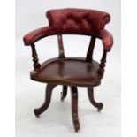 A LATE 19TH / EARLY 20TH CENTURY MAHOGANY SWIVEL CHAIR with red leatherette upholstered arms