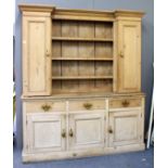 A 19TH CENTURY PINE KITCHEN DRESSER with shaped cornice above open shelves with two cupboards,