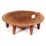 AN OLD CIRCULAR CARVED WOODEN TONGAN FEASTING BOWL on six tapering feet 59.5cm diameter x 17.5cm