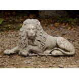 A RECONSTITUTED STONE CAST SCULPTURE OF A RECLINING LION 68cm wide x 34cm high