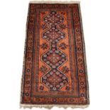 A BELOUCH RED GROUND RUG with a multiple banded border and geometric foliate decoration 298cm x