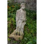 A RECONSTITUTED STONE SCULPTURE of a gentleman standing by a tree stump and wearing 19th century