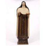 A LATE 18TH CENTURY CONTINENTAL CARVED AND PAINTED SCULPTURE of a nun holding a book, with insect