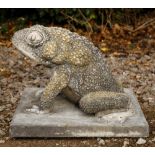 A LARGE CAST STONE SCULPTURE OF A TOAD seated on a square plinth