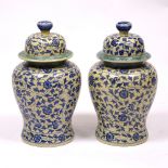 A PAIR OF CHINESE PORCELAIN BALUSTER VASES AND COVERS decorated with blue flowers on a yellow