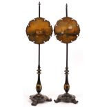 A PAIR OF VICTORIAN BLACK LACQUERED PAPIER MACHE POLE SCREENS each with painted scenes to the