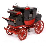 A PAINTED WOODEN MODEL OF A 19TH CENTURY STAGECOACH in black and red, 35cm long x 28cm high