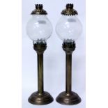 A PAIR OF ANTIQUE BRASS CANDLE LANTERNS OR STUDENT'S LAMPS with globular glass shades and turned