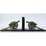 A PAIR OF BOOKENDS each mounted with brass cannons, 23cm wide (2)