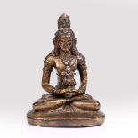 A Tibetan solid cast bronze figure of Tara 19th Century in a seated position with legs crossed