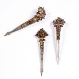 Three Indian gilt metal turban pins each inset with rubies and sapphires, circular and single cut