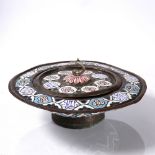 A Syrian brass lidded basin with blue, red and white enamel within an embossed pattern of medallions