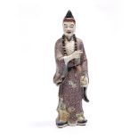 A large Chinese polychrome porcelain Lohan early 20th Century the standing figure holding a bottle