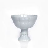 A Chinese porcelain stem cup early 19th Century decorated with an allover white glaze, eight lotus