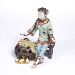 A Chinese glazed model of a girl with chicks 20th Century the seated figure beside a basket and